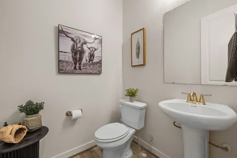 a bathroom with a toilet sink and mirror