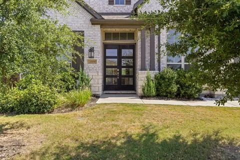 a view of yellow house with a large tree