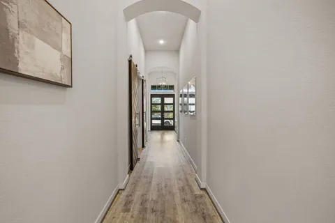 a view of a hallway with wooden floor and staircase