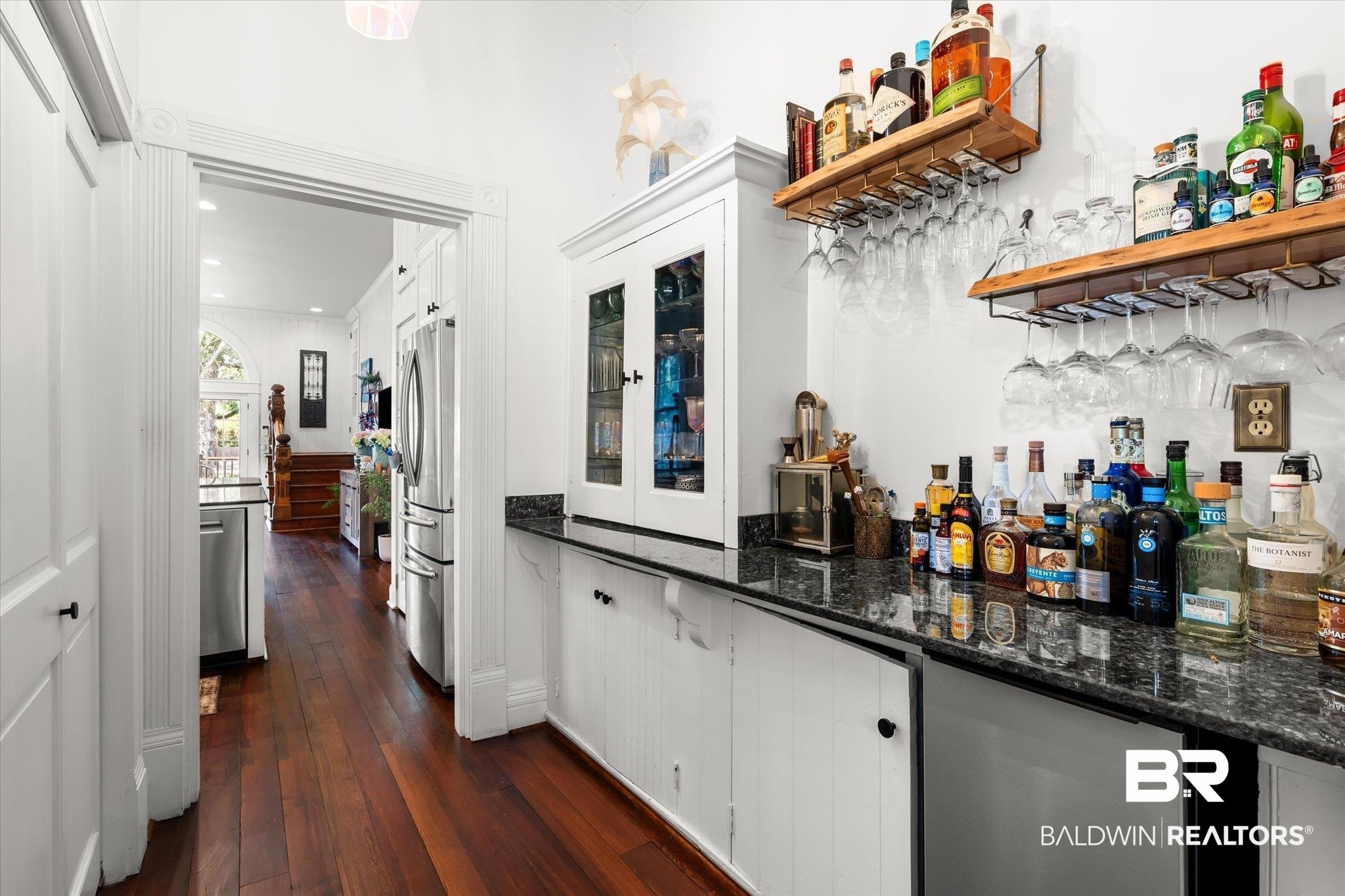 1210 Government Street Mobile, AL 36604 - Photo 11 of 37 Bar featuring dark wood-type flooring, white cabinets, stainless steel refrigerator, and dark stone countertops