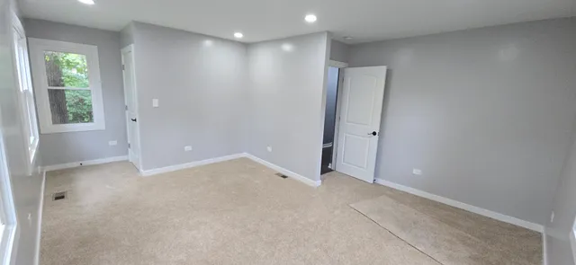 an empty room with windows and closet