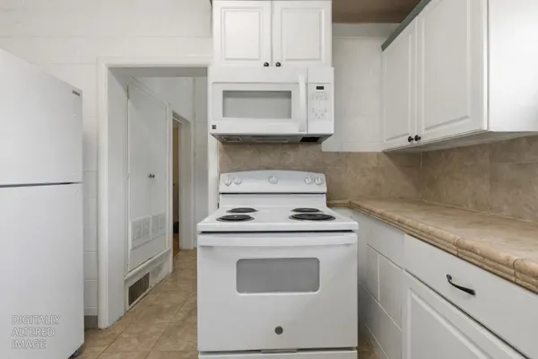 a kitchen with white cabinets and white appliances