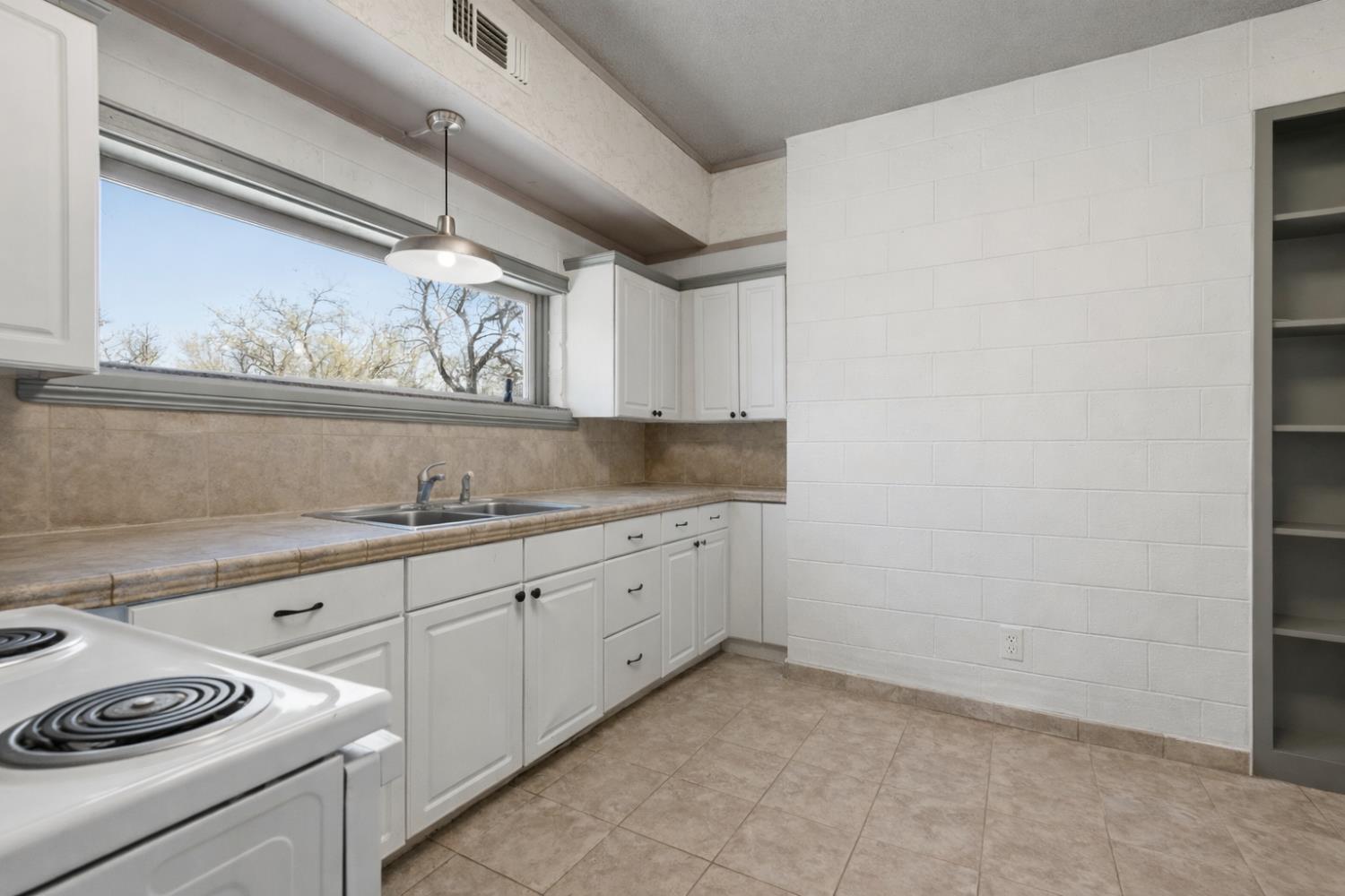 724 Webster Street Colusa, CA 95932 - Photo 11 of 48 a kitchen with granite countertop white cabinets and white appliances