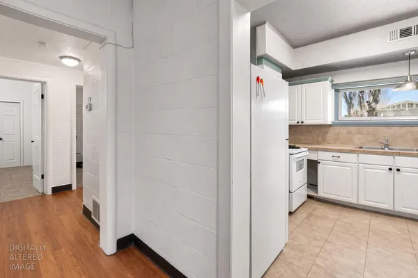 a kitchen with a refrigerator and white cabinets