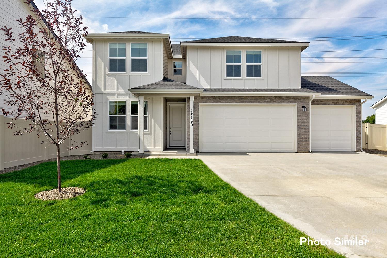 4634 West Wapoot Street Meridian, ID 83646 - Photo 1 of 1 View of front facade featuring a shingled roof, board and batten siding, concrete driveway, and brick siding