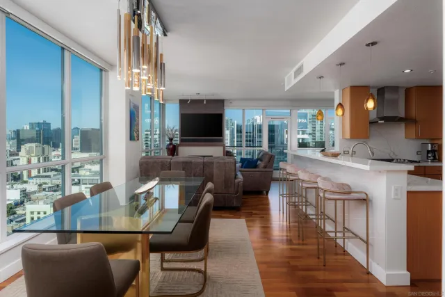a living room with dining table and couches with kitchen view
