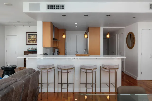 a living room with furniture large window and wooden floor