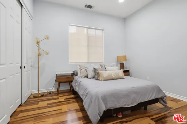 a bedroom with a bed and wooden floor