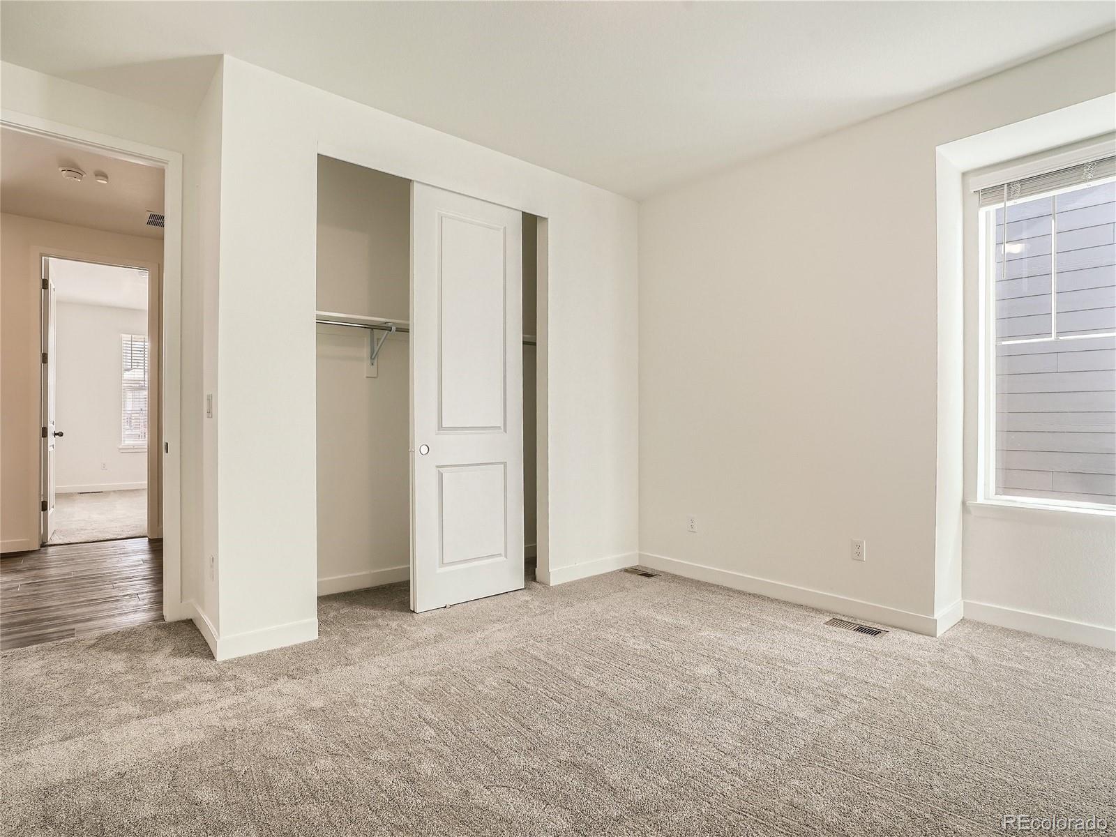 9975 Uvalda Street Commerce City, CO 80022 - Photo 20 of 29 an empty room with windows and closet