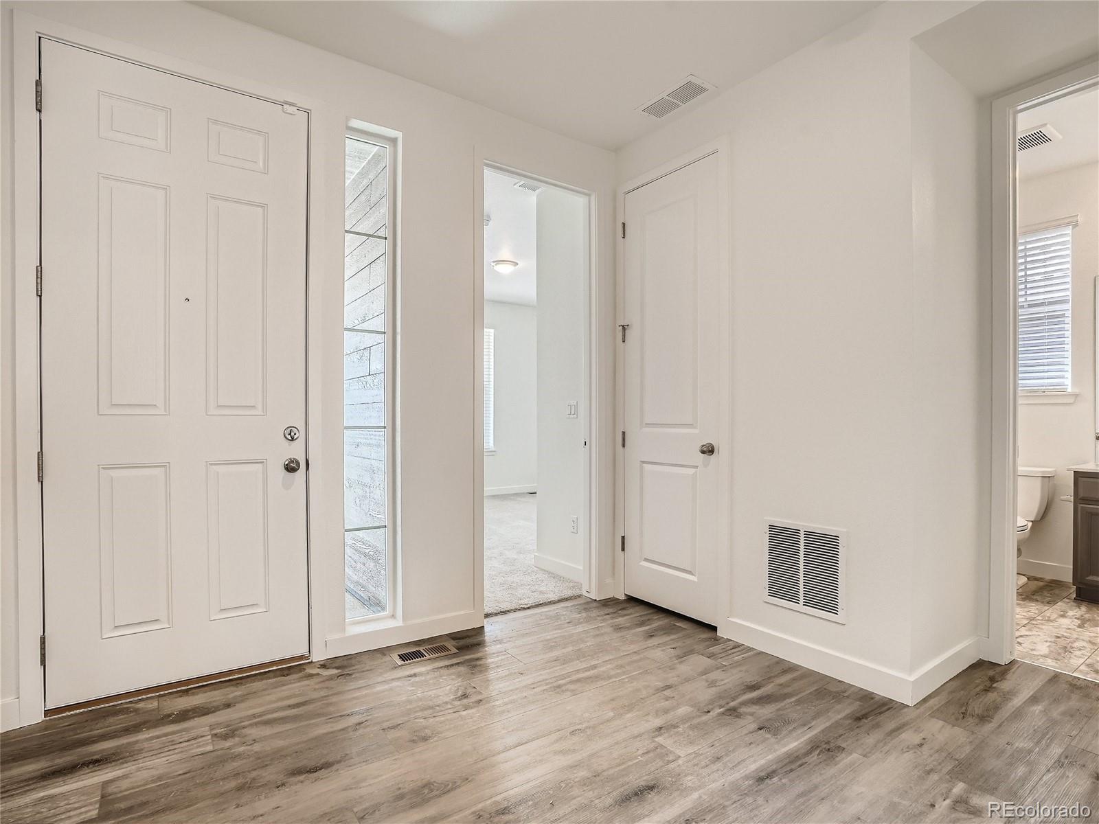 9975 Uvalda Street Commerce City, CO 80022 - Photo 4 of 29 an empty room with wooden floor and windows
