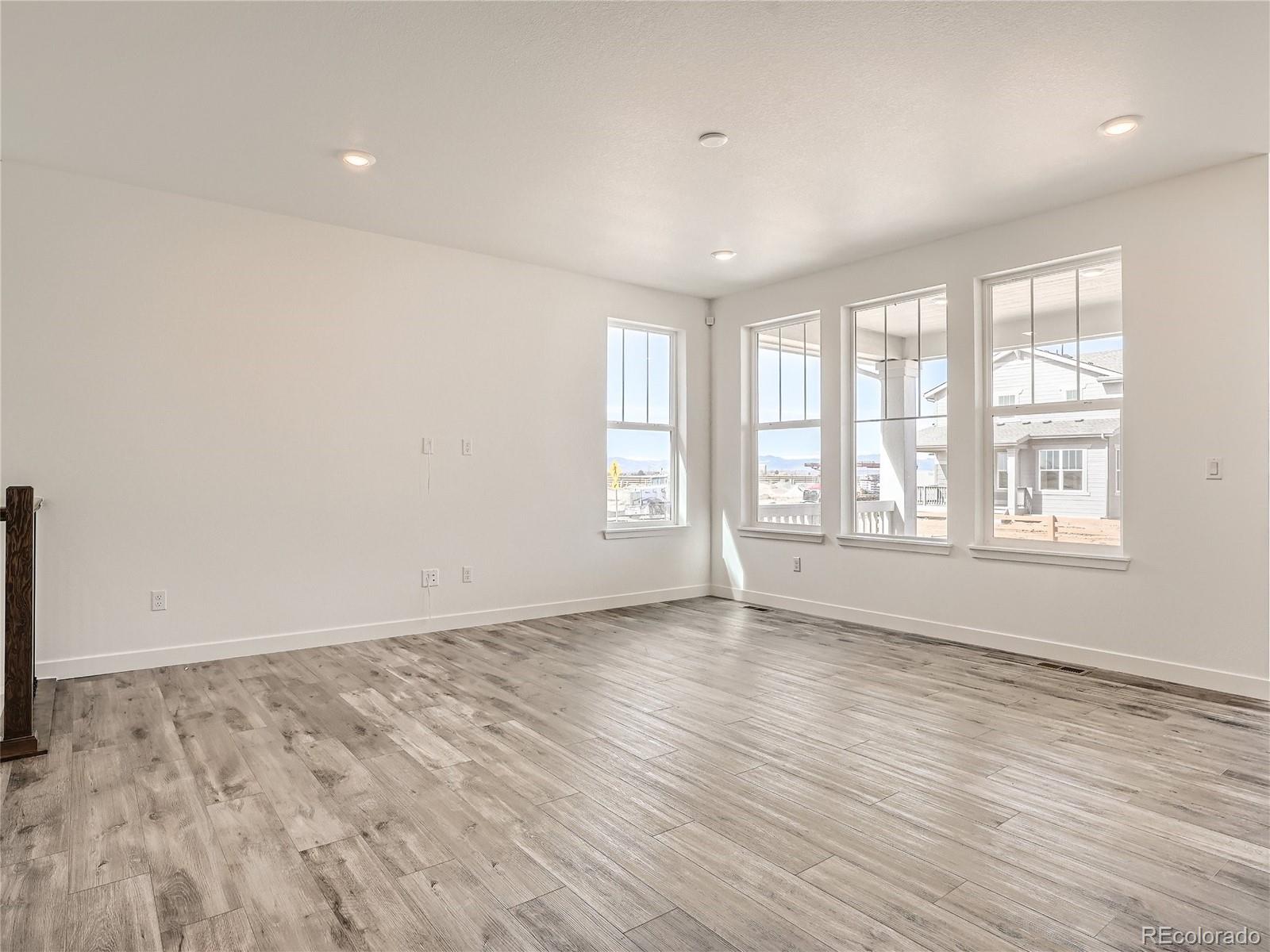 9975 Uvalda Street Commerce City, CO 80022 - Photo 5 of 29 an empty room with wooden floor and windows