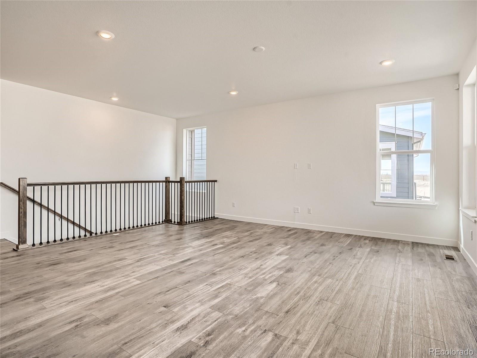 9975 Uvalda Street Commerce City, CO 80022 - Photo 6 of 29 wooden floor in an empty room with a window