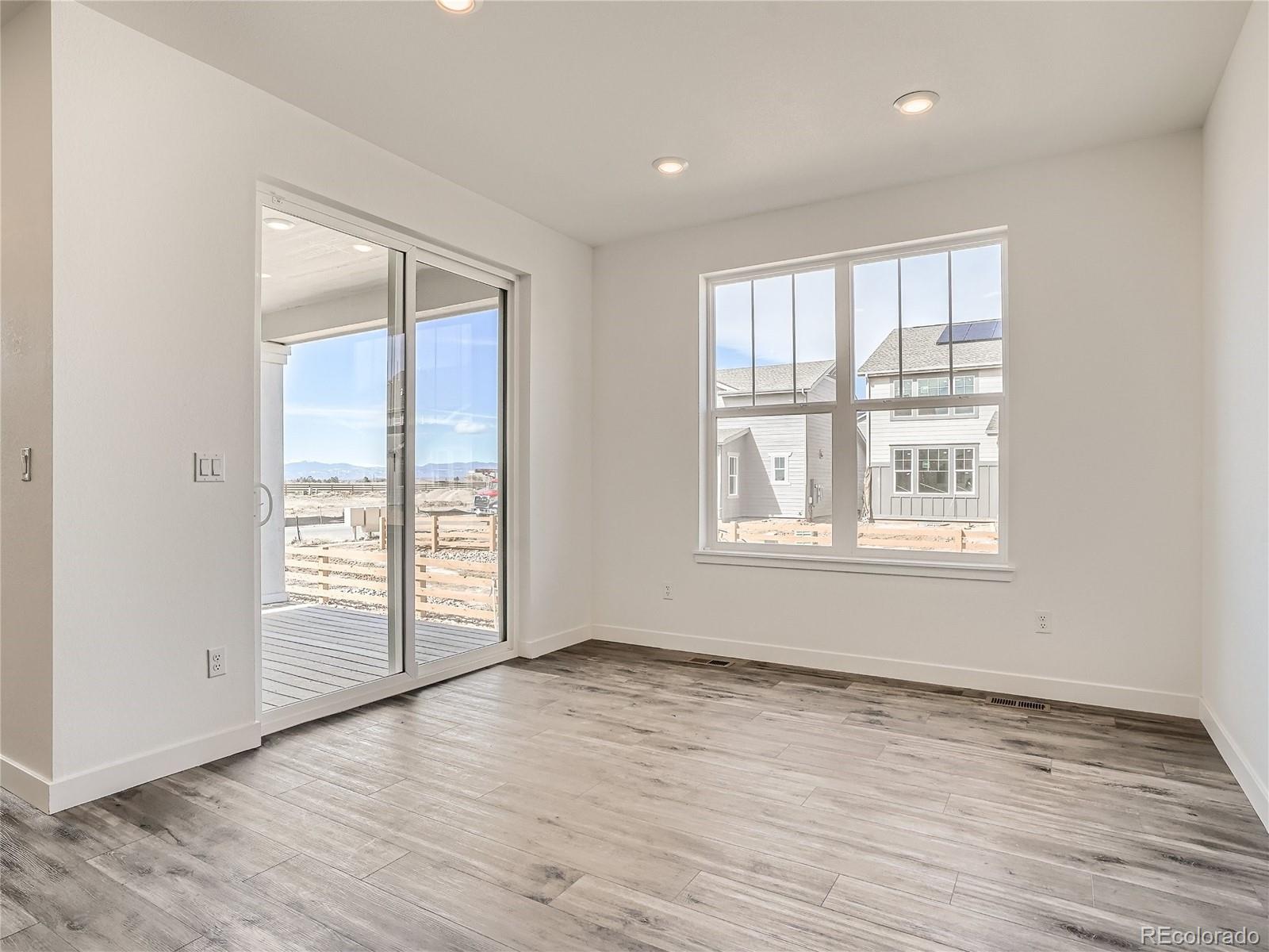 9975 Uvalda Street Commerce City, CO 80022 - Photo 8 of 29 a view of an empty room with wooden floor and a window