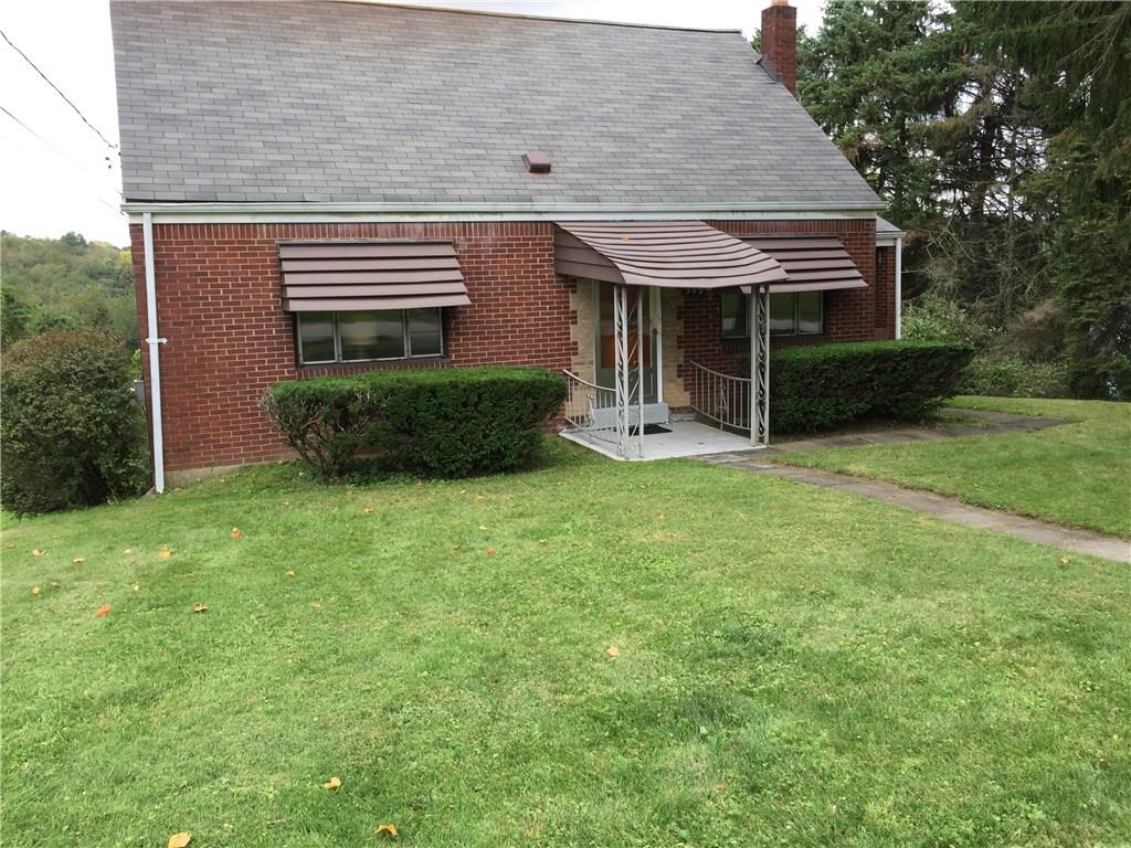 Brick one and a half story home with three bedrooms and a garage