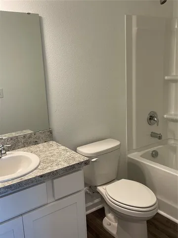 a bathroom with a granite countertop toilet a sink and bathtub