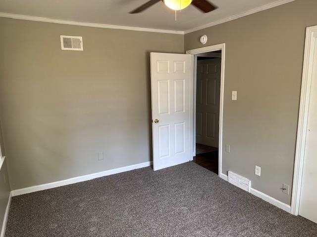 1734 Berwind Road Memphis, TN 38116 - Photo 30 of 40 Unfurnished bedroom featuring crown molding, visible vents, baseboards, and dark colored carpet