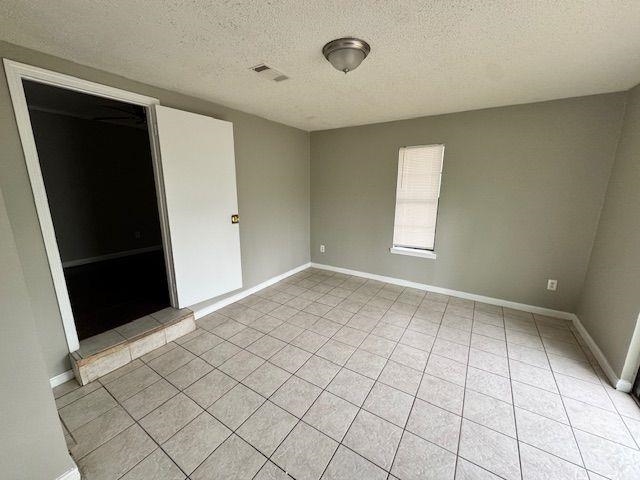 1734 Berwind Road Memphis, TN 38116 - Photo 34 of 40 Spare room featuring baseboards, a textured ceiling, visible vents, and light tile patterned floors