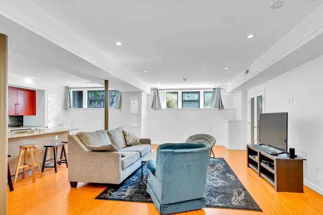 a living room with furniture a flat screen tv and a dining table