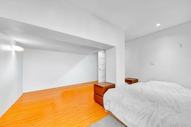 a bedroom with a bed and a night stand