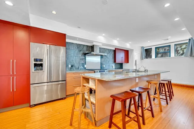 a kitchen with stainless steel appliances granite countertop a refrigerator and a stove top oven