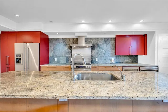 a kitchen with stainless steel appliances granite countertop a sink and a refrigerator