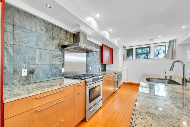a kitchen with stainless steel appliances granite countertop a sink stove and cabinets