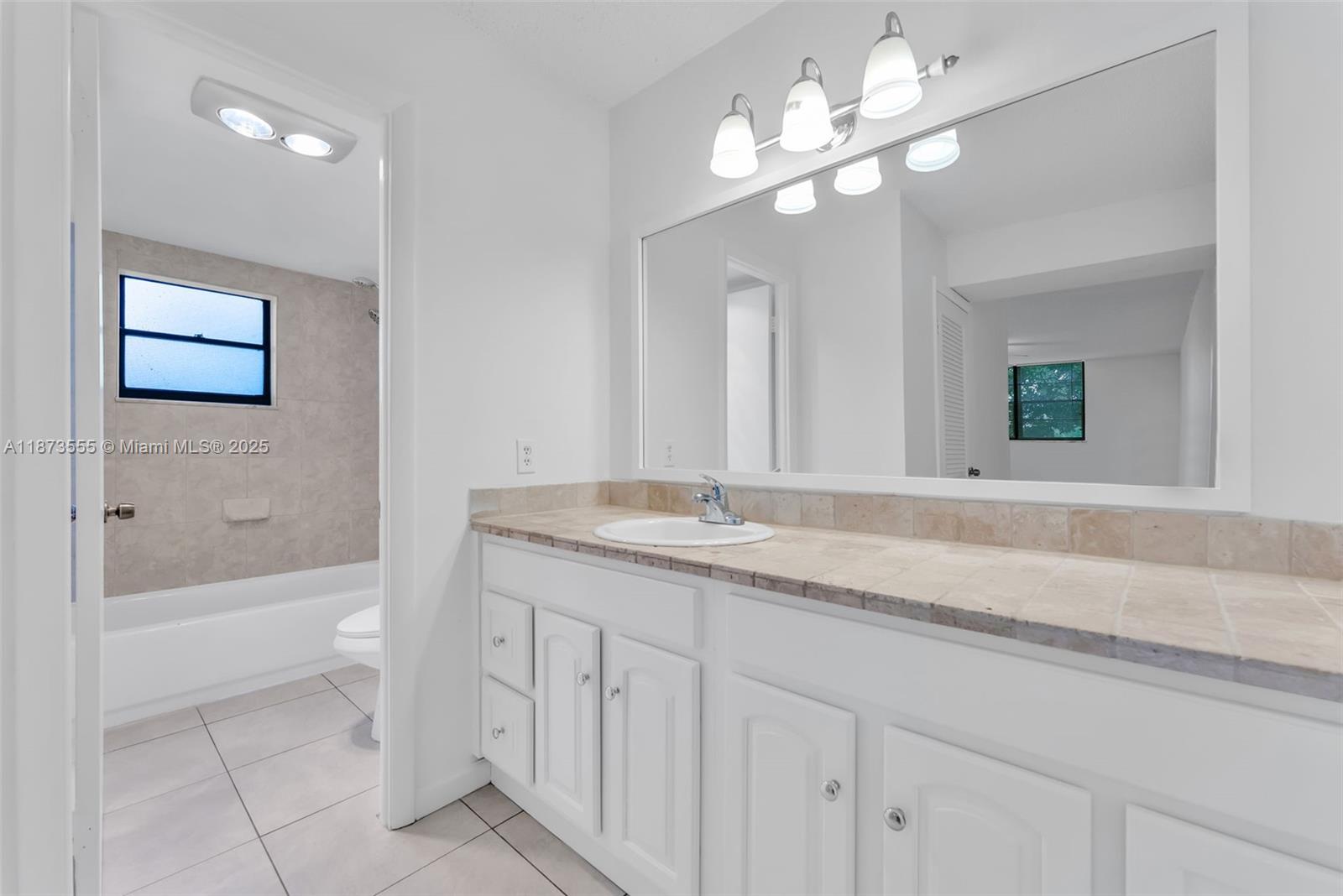 3100 North Pine Island Road, Unit 304 Sunrise, FL 33351 - Photo 7 of 24 a bathroom with a granite countertop sink a toilet and a bathtub
