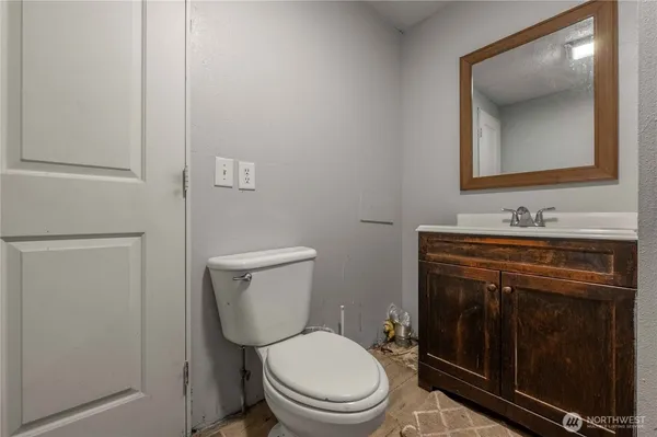 a bathroom with a toilet a sink a vanity and mirror