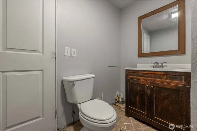 a bathroom with a toilet a sink a vanity and mirror