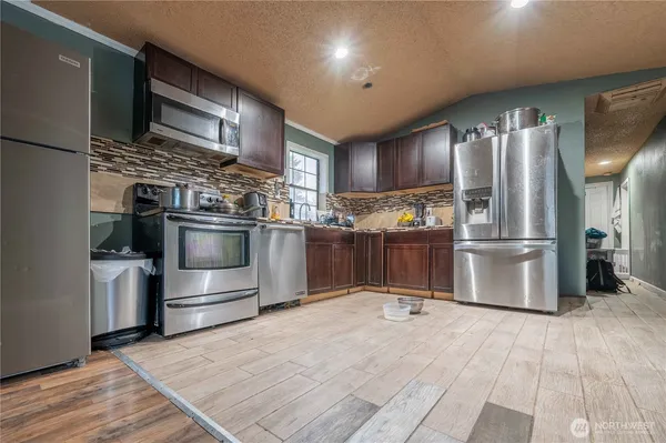 a kitchen with stainless steel appliances granite countertop a refrigerator and a stove top oven