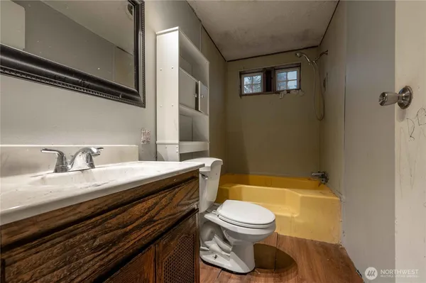 a bathroom with a granite countertop toilet sink and mirror