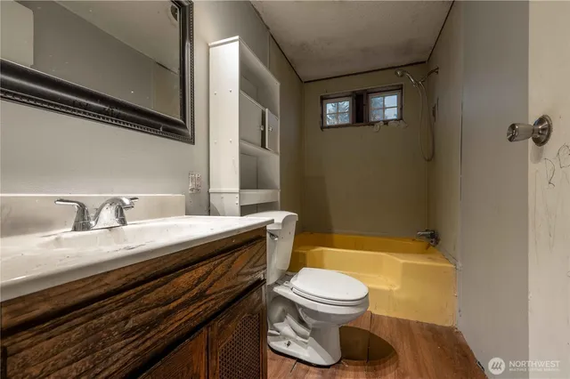 a bathroom with a granite countertop toilet sink and mirror