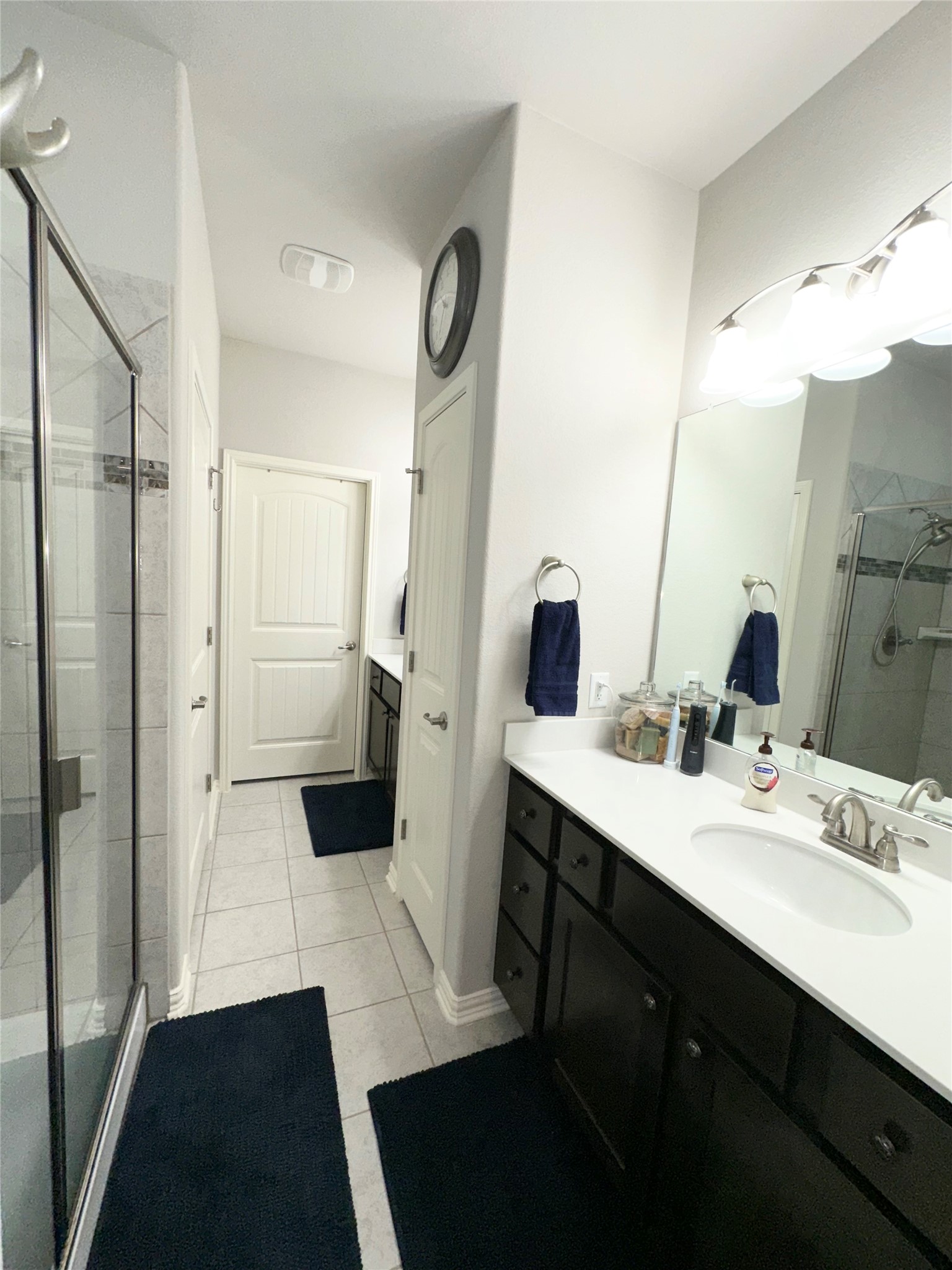 5721 Baythorne Drive Austin, TX 78747 - Photo 11 of 22 a bathroom with a double vanity sink a toilet a mirror and shower