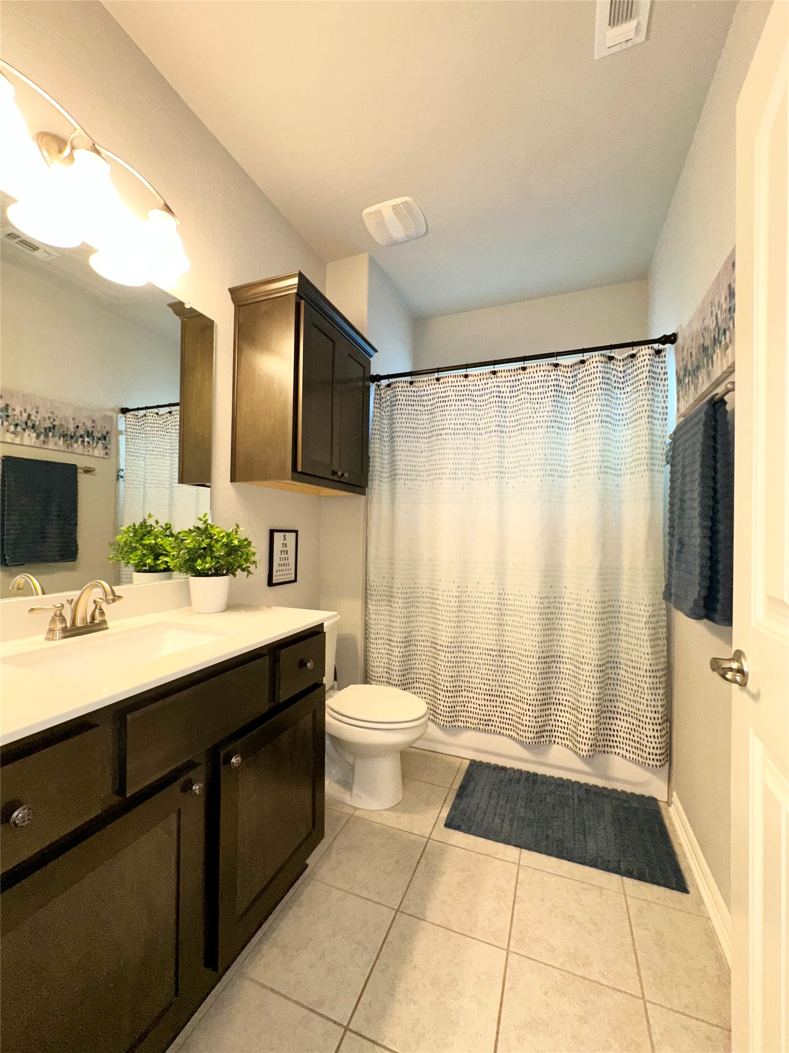 5721 Baythorne Drive Austin, TX 78747 - Photo 15 of 22 a bathroom with a double vanity sink toilet mirror and shower