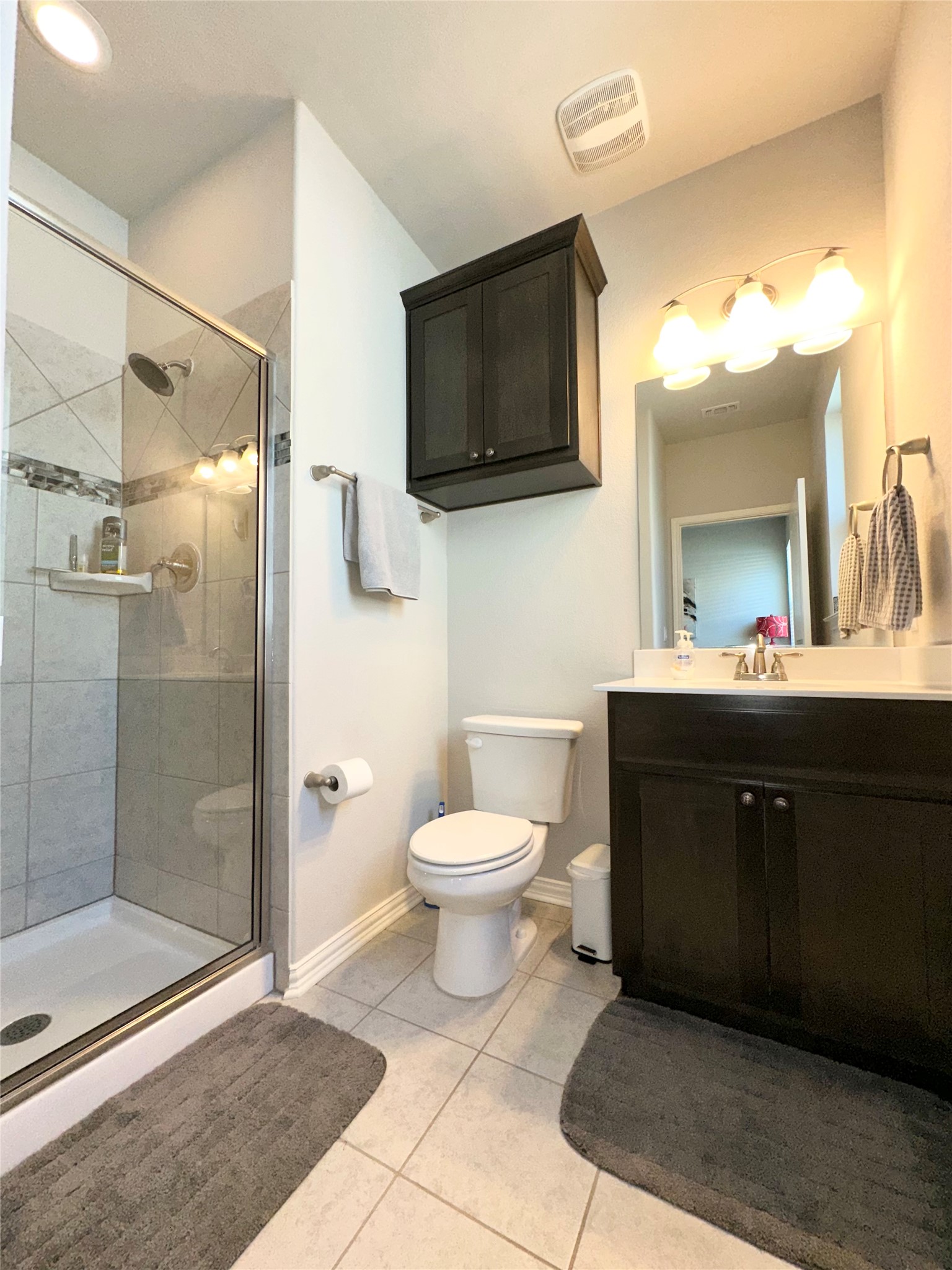 5721 Baythorne Drive Austin, TX 78747 - Photo 17 of 22 a bathroom with a toilet a sink and mirror