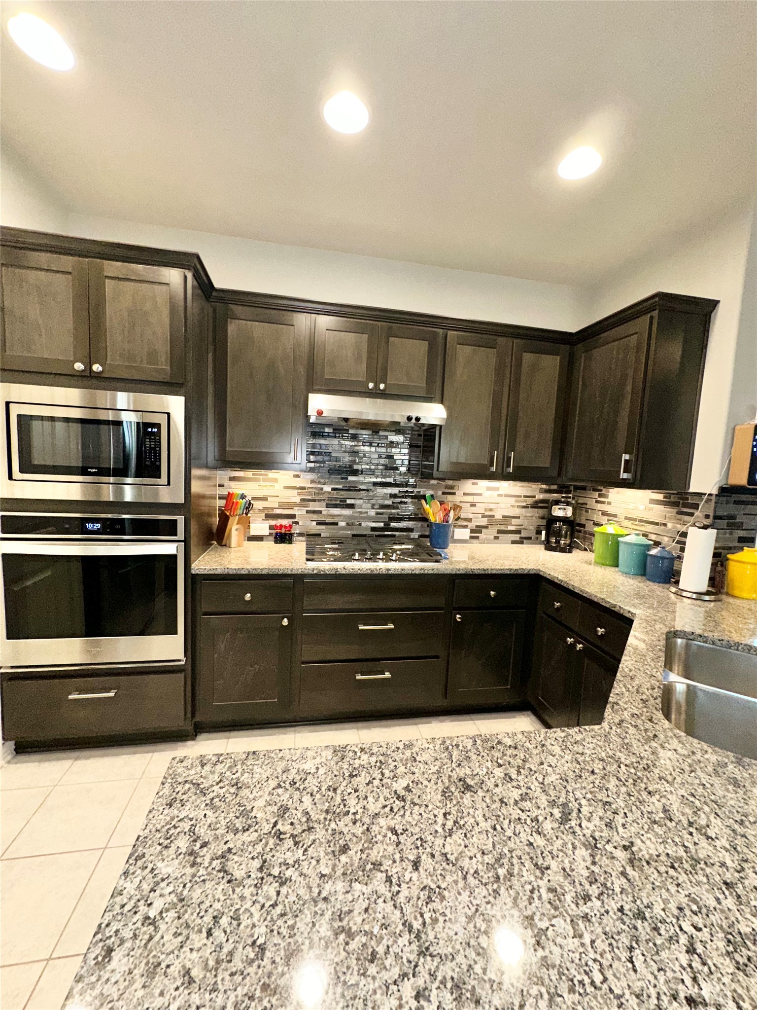 5721 Baythorne Drive Austin, TX 78747 - Photo 5 of 22 a kitchen with stainless steel appliances granite countertop a stove a sink and a microwave