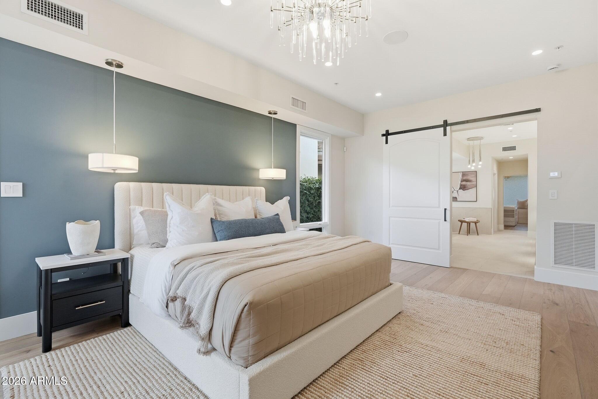 7475 East Gainey Ranch Road, Unit 7 Scottsdale, AZ 85258 - Photo 33 of 77 a bedroom with a large bed and a chandelier