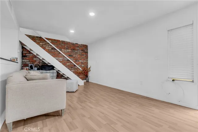 a view of an empty room with wooden floor stairs