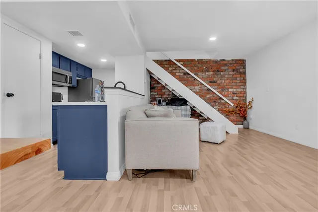 a view of a kitchen with furniture and wooden floor