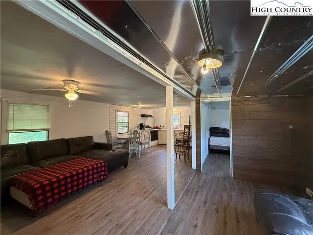 a kitchen with stainless steel appliances a dining table chairs and wooden floor