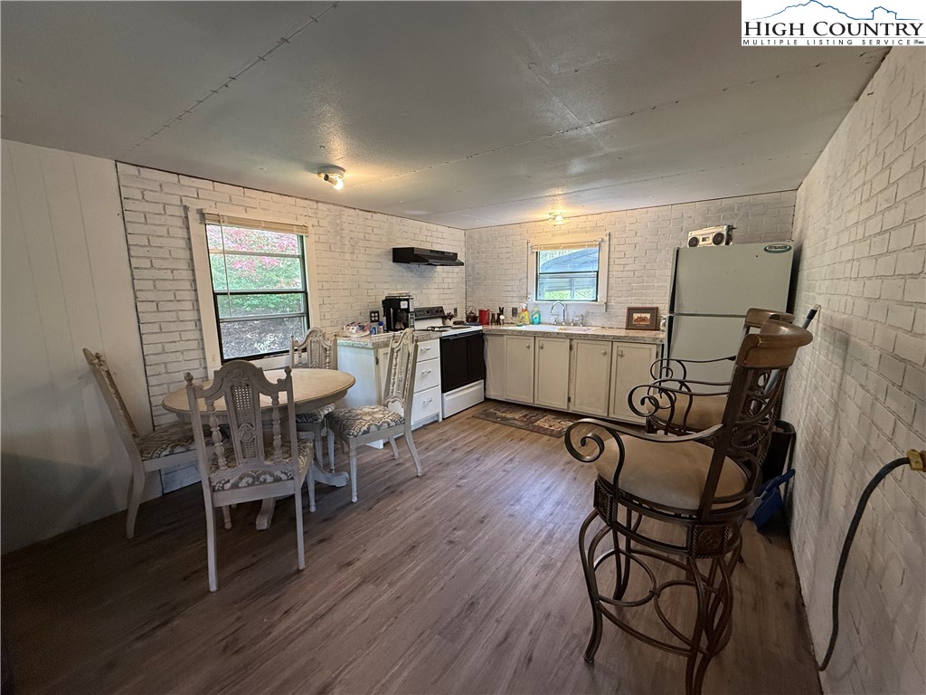 253 Bobby Rash Road Warrensville, NC 28693 - Photo 6 of 15 a kitchen with stainless steel appliances a dining table chairs and wooden floor