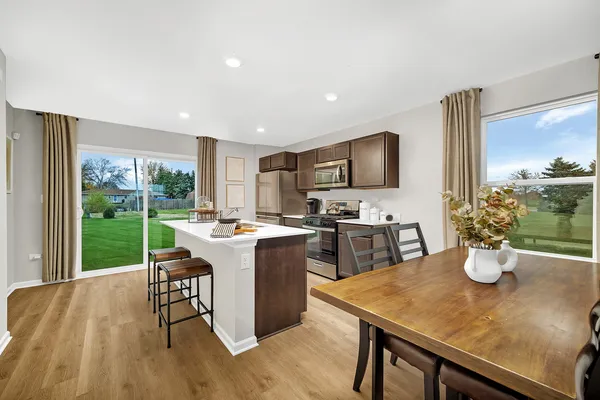 a kitchen with refrigerator and chairs