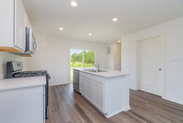 a kitchen with stainless steel appliances granite countertop a stove a sink and a refrigerator