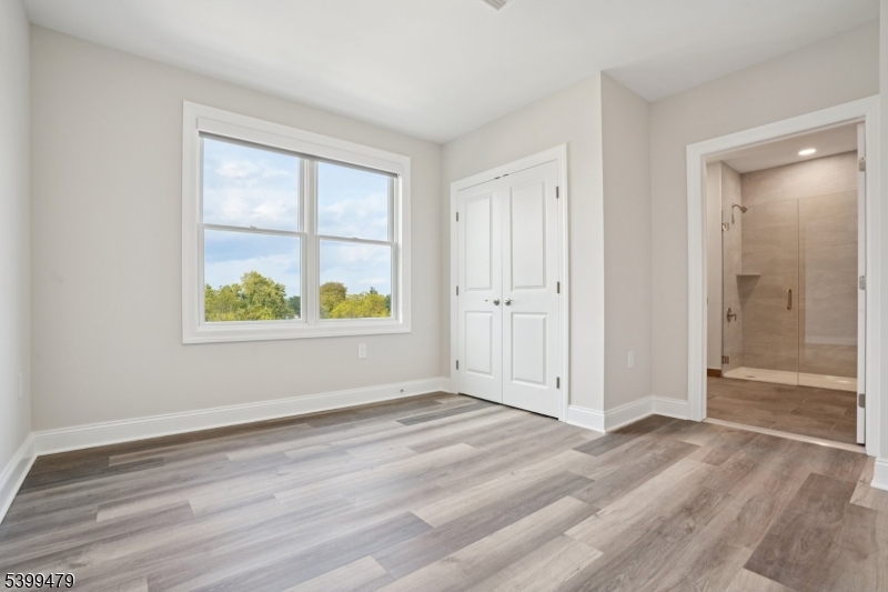 246 Main Street, Unit 202 Chatham, NJ 07928 - Photo 12 of 29 an empty room with wooden floor and windows