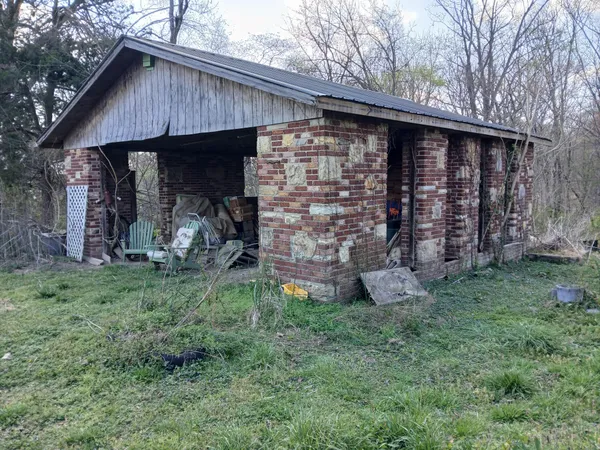 a view of a barn with wooden fence