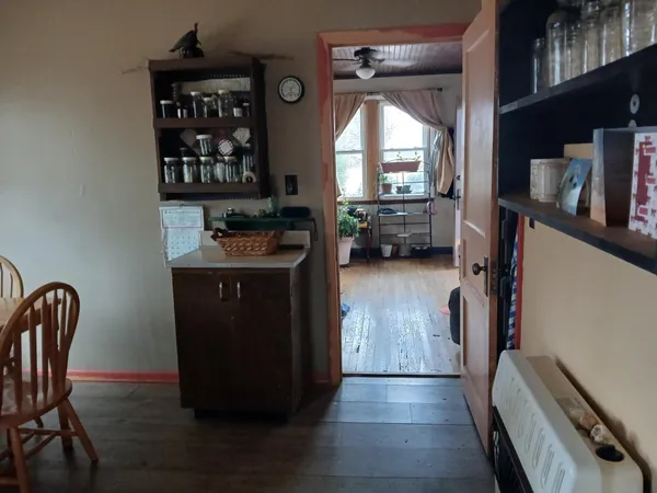 a view of a hallway with wooden floor and windows