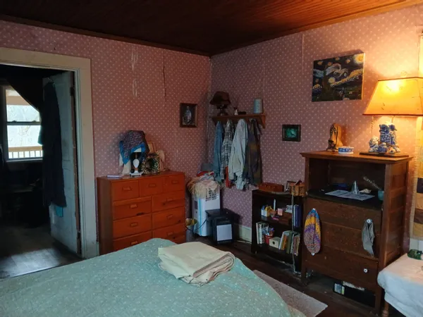 a bed room with a bed and a lamp on dresser