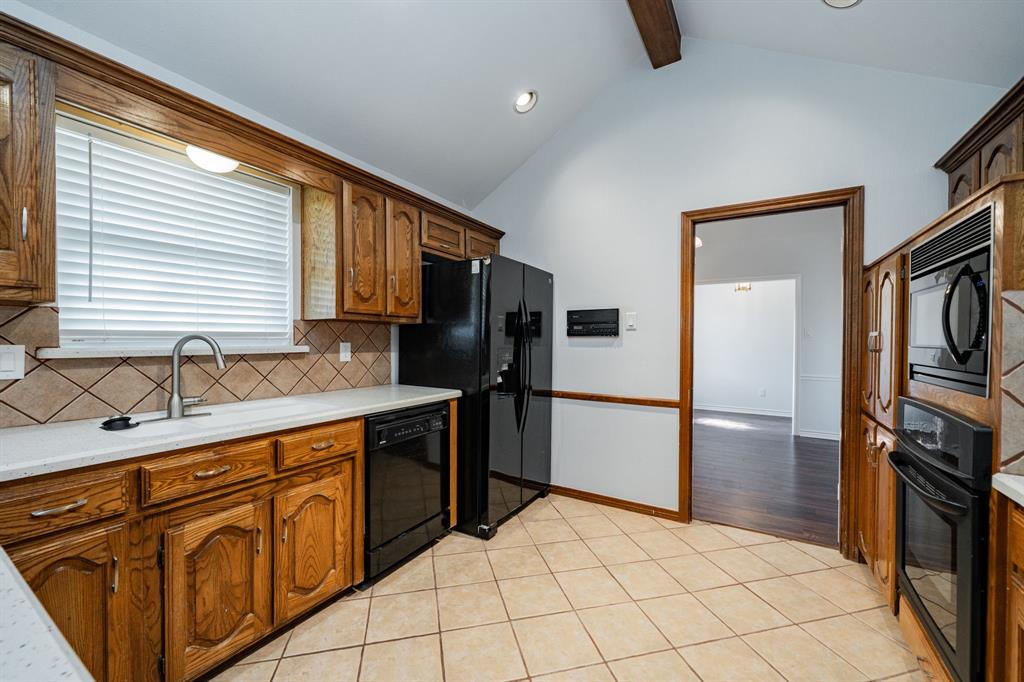 8304 Navigation Drive Rowlett, TX 75088 - Photo 11 of 40 Kitchen featuring light tile patterned floors, black appliances, backsplash, beamed ceiling, and recessed lighting