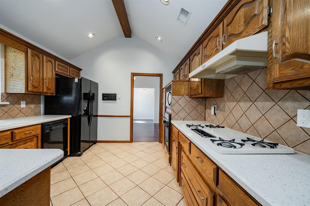 8304 Navigation Drive Rowlett, TX 75088 - Photo 12 of 40 Kitchen with decorative backsplash, light stone counters, brown cabinetry, and recessed lighting