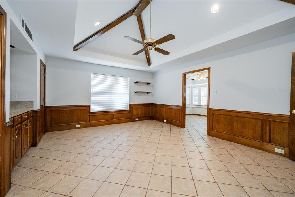8304 Navigation Drive Rowlett, TX 75088 - Photo 16 of 40 Spare room featuring a tray ceiling, ceiling fan, light tile patterned flooring, and wainscoting